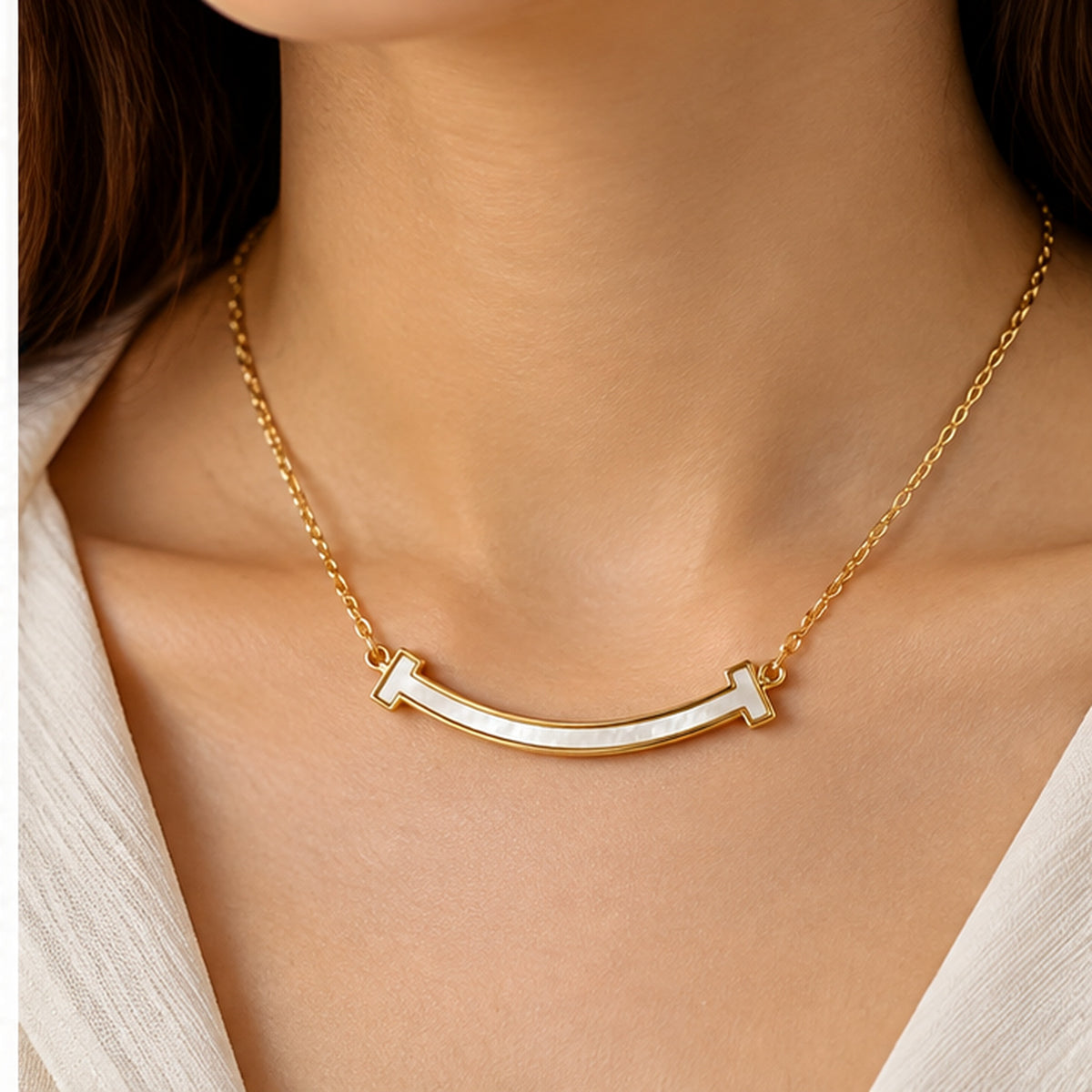 Curved mother of pearl bar necklace in gold worn on the neck