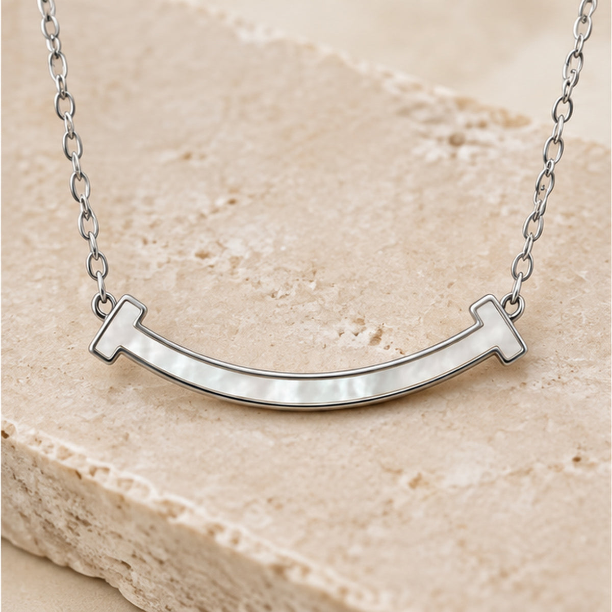 Curved mother of pearl bar necklace in silver styled on neutral stone