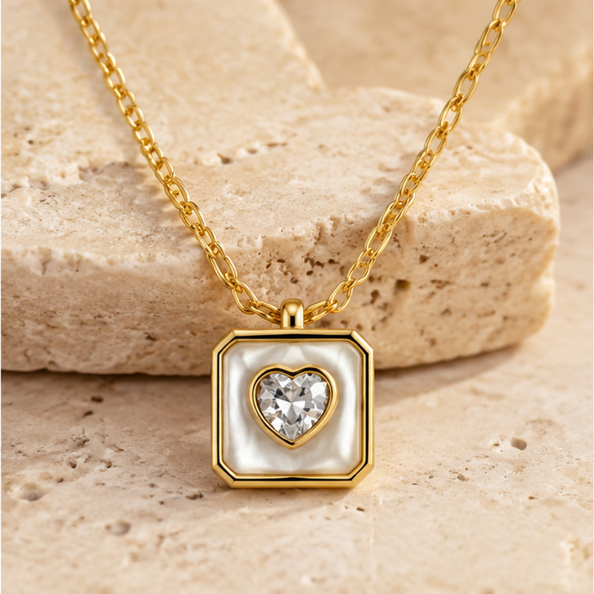 Gold heart crystal mother of pearl square pendant necklace styled on neutral stone