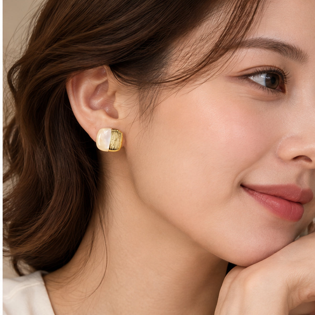 Mother of pearl square stud earring in gold worn on the ear
