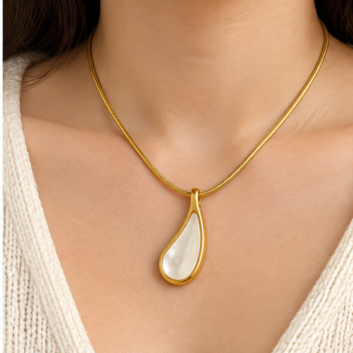 Mother of pearl teardrop pendant necklace in gold worn on the neck