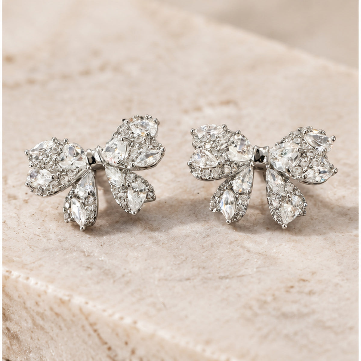 NZGO Pearl crystal bow stud earrings in a neutral studio setting