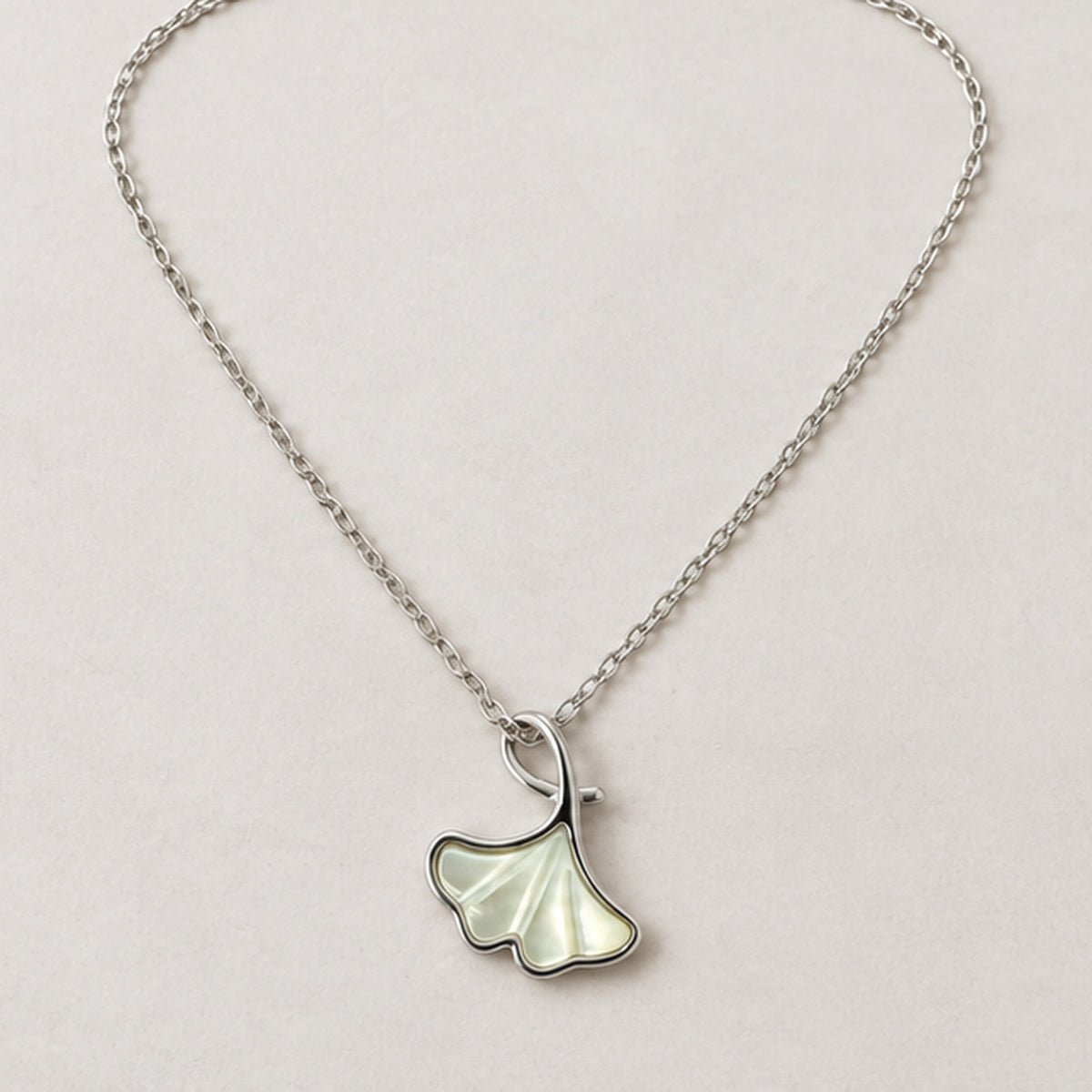 NZGO Pearl ginkgo leaf pendant necklace in a neutral studio setting