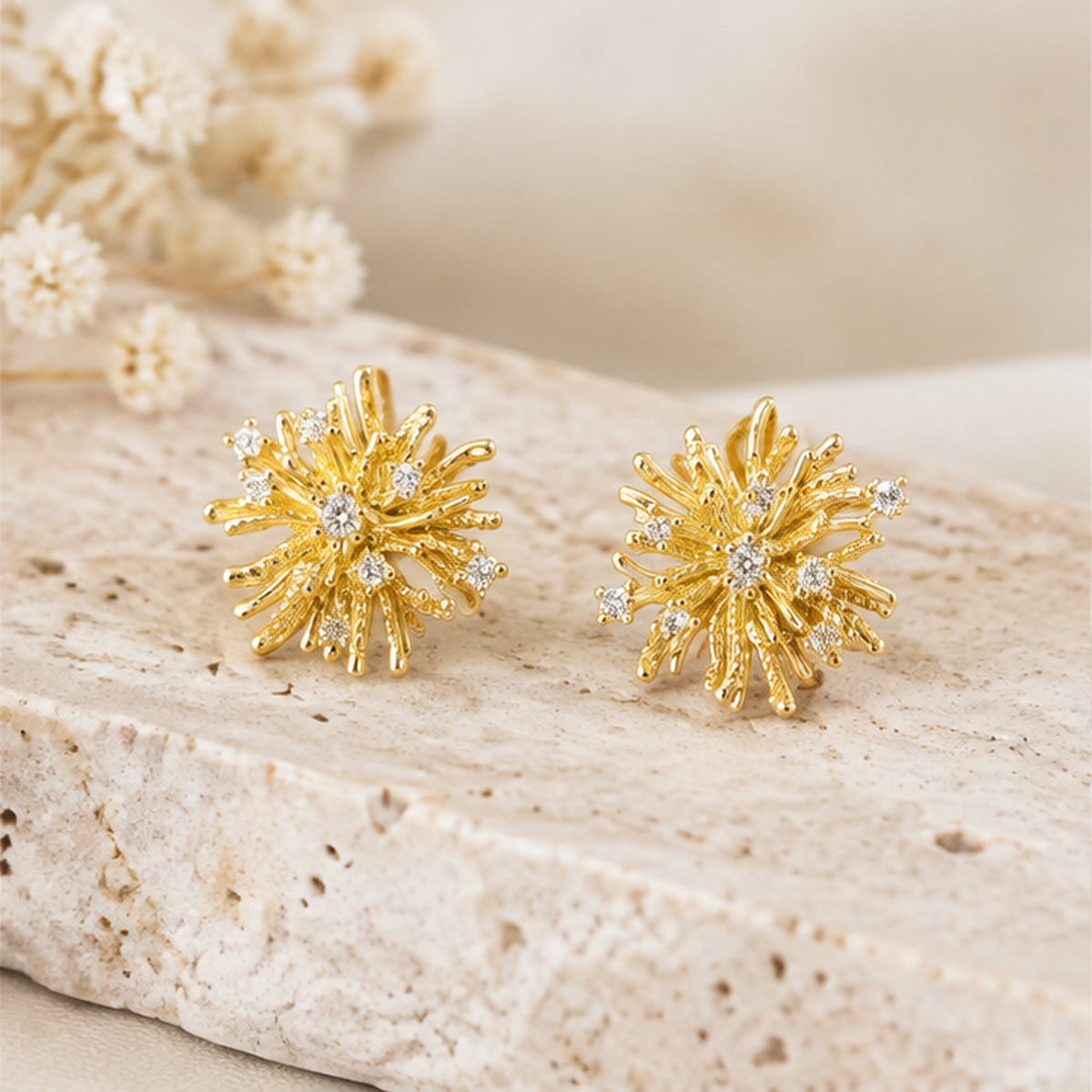 NZGO Pearl gold floral starburst stud earrings styled on neutral stone