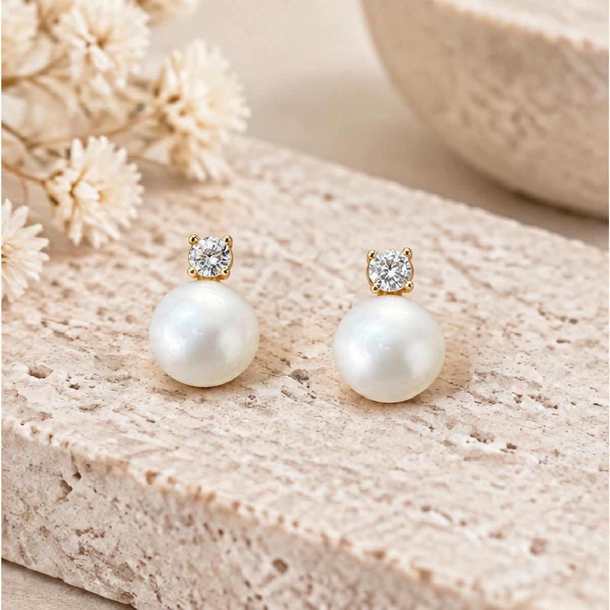 NZGO Pearl real pearl and clear stone stud earrings styled on neutral stone