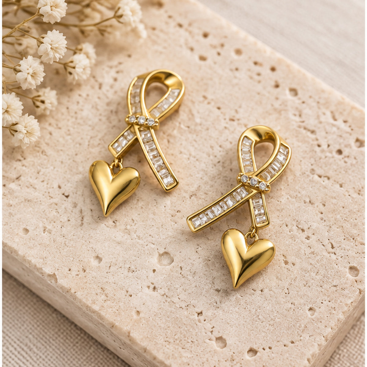 NZGO Pearl ribbon heart drop earrings in a neutral studio setting