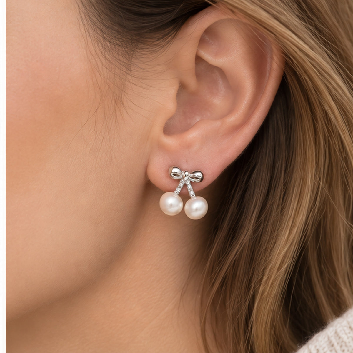 Real pearl bow double drop stud earring worn on a model at realistic scale
