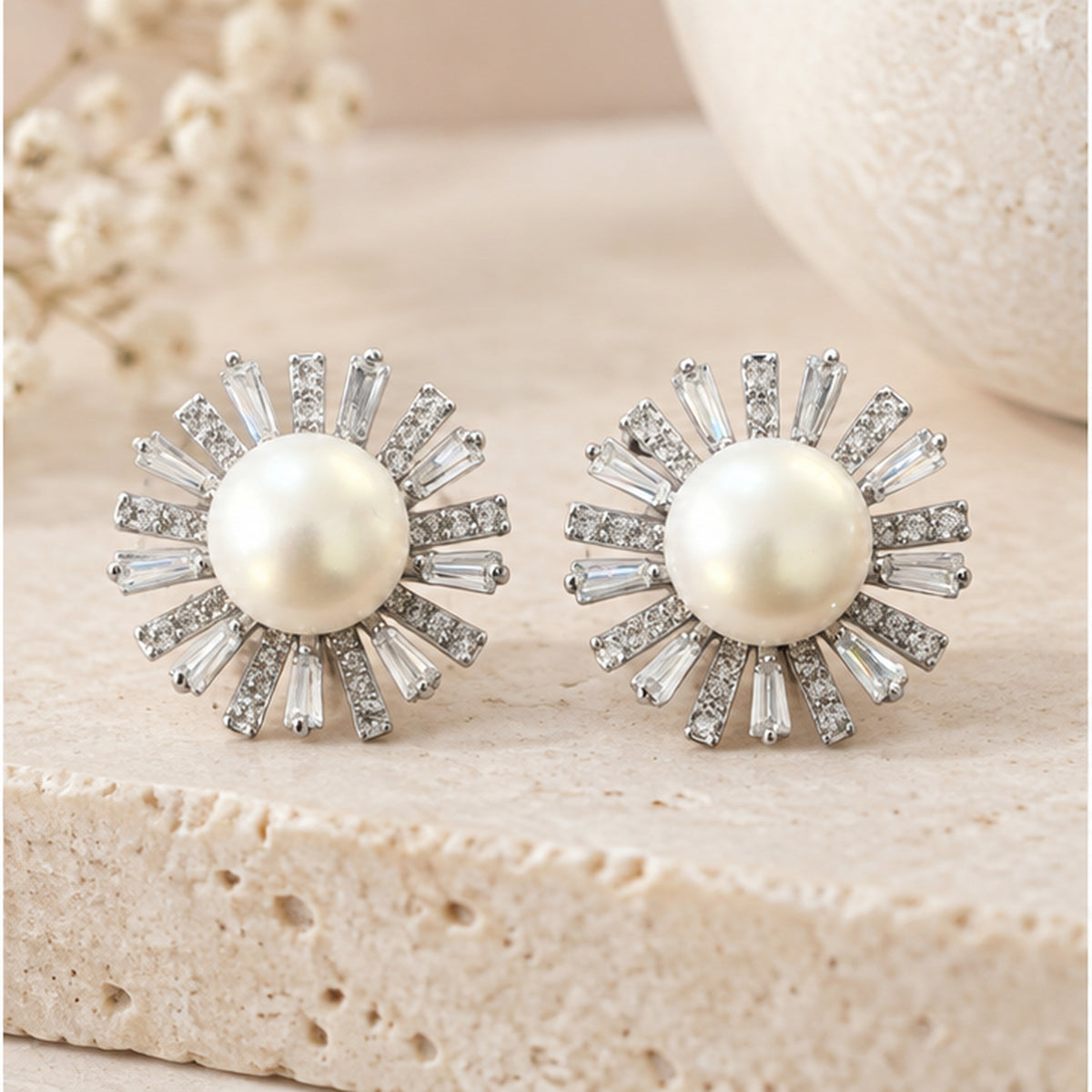 Real pearl sunburst stud earrings with clear stone accents in a neutral luxury studio setting